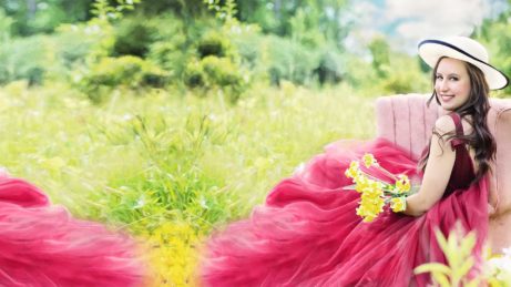 Pozadí k ochutnávce e-booku Hezčí život díky sepetřijeí, atraktivní žena sedí uprostřed louky s květinami na klíně
