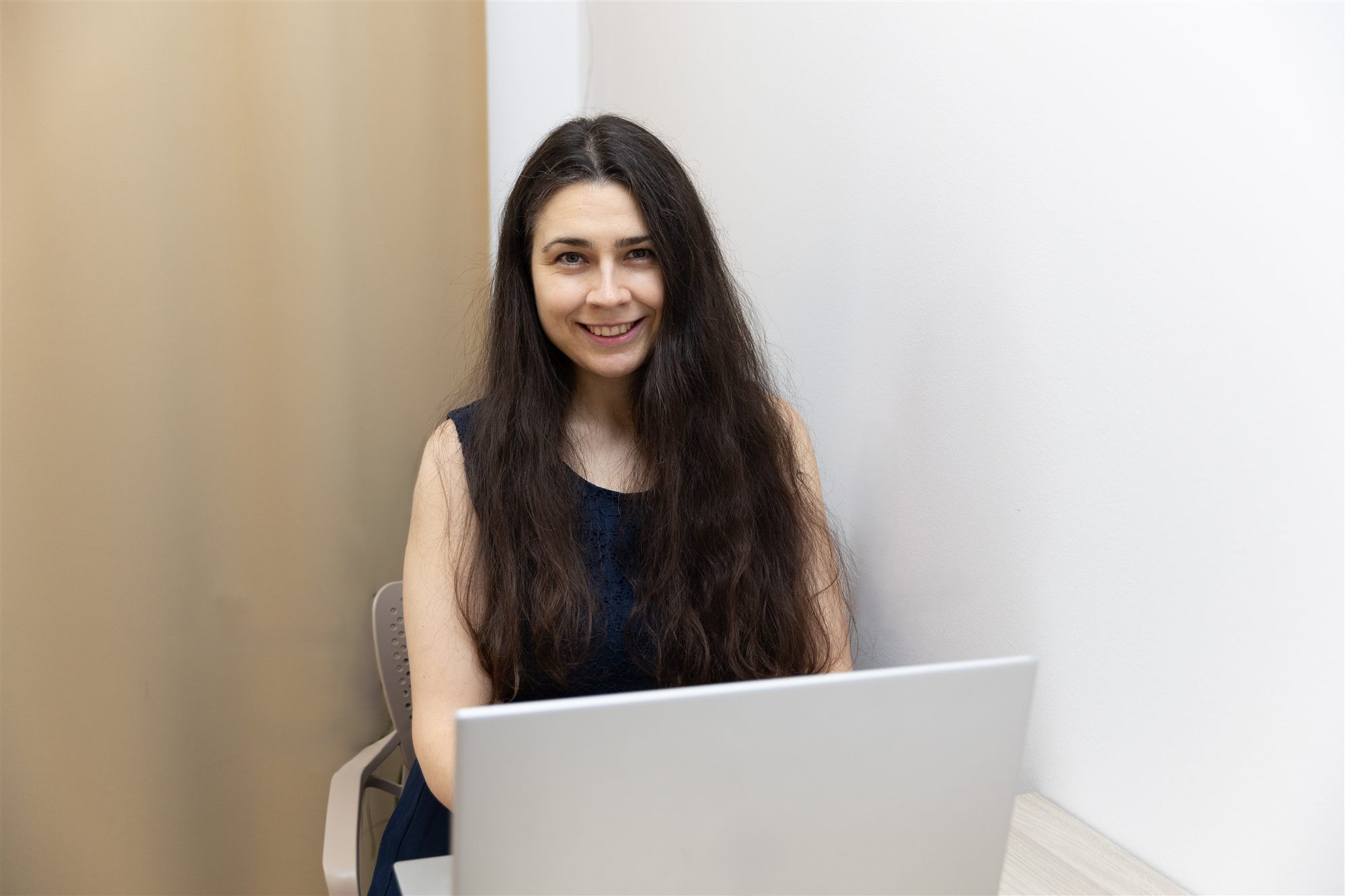 Daniela z Nacházení s úsměvem pracuje u notebooku